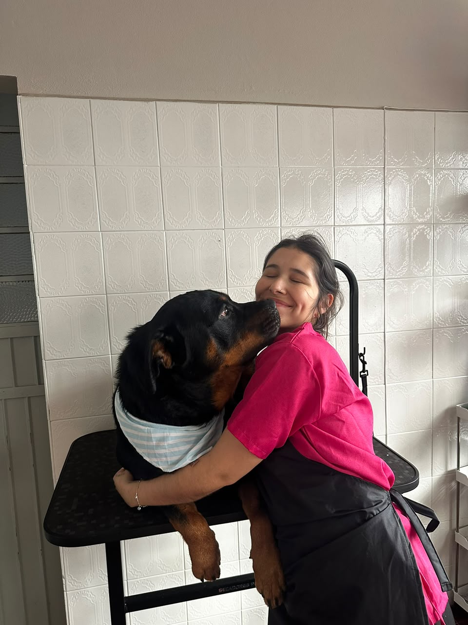 Khatlyn abraçando um cachorro grande durante o atendimento